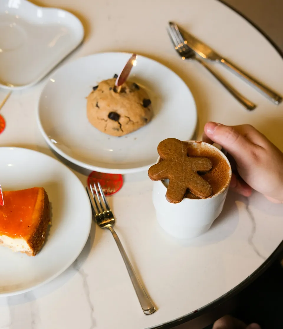 Hands around a hot chocolate at a marble table