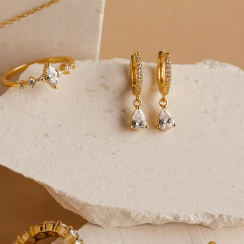 Gold hoop earrings with clear pear-shaped drops
