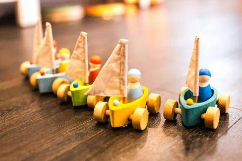 The shop&rsquo;s photo of five wooden sailboat toys in a row